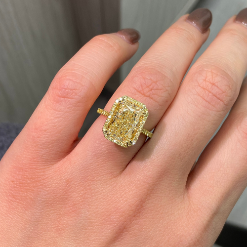 Old money yellow halo diamond engagement ring featuring a GIA certified light yellow elongated radiant diamond with VS2 clarity.