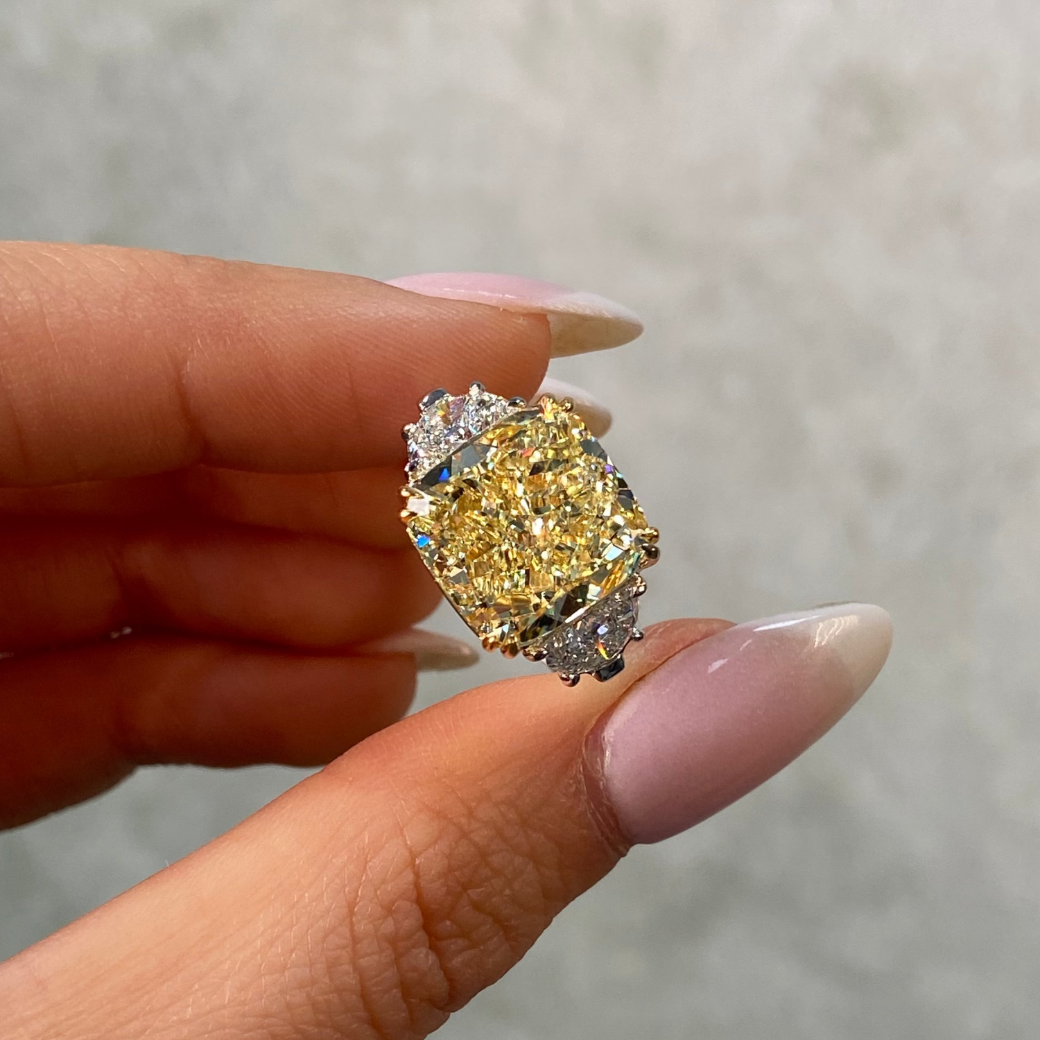 10 carat fancy light yellow diamond ring held by female hand 