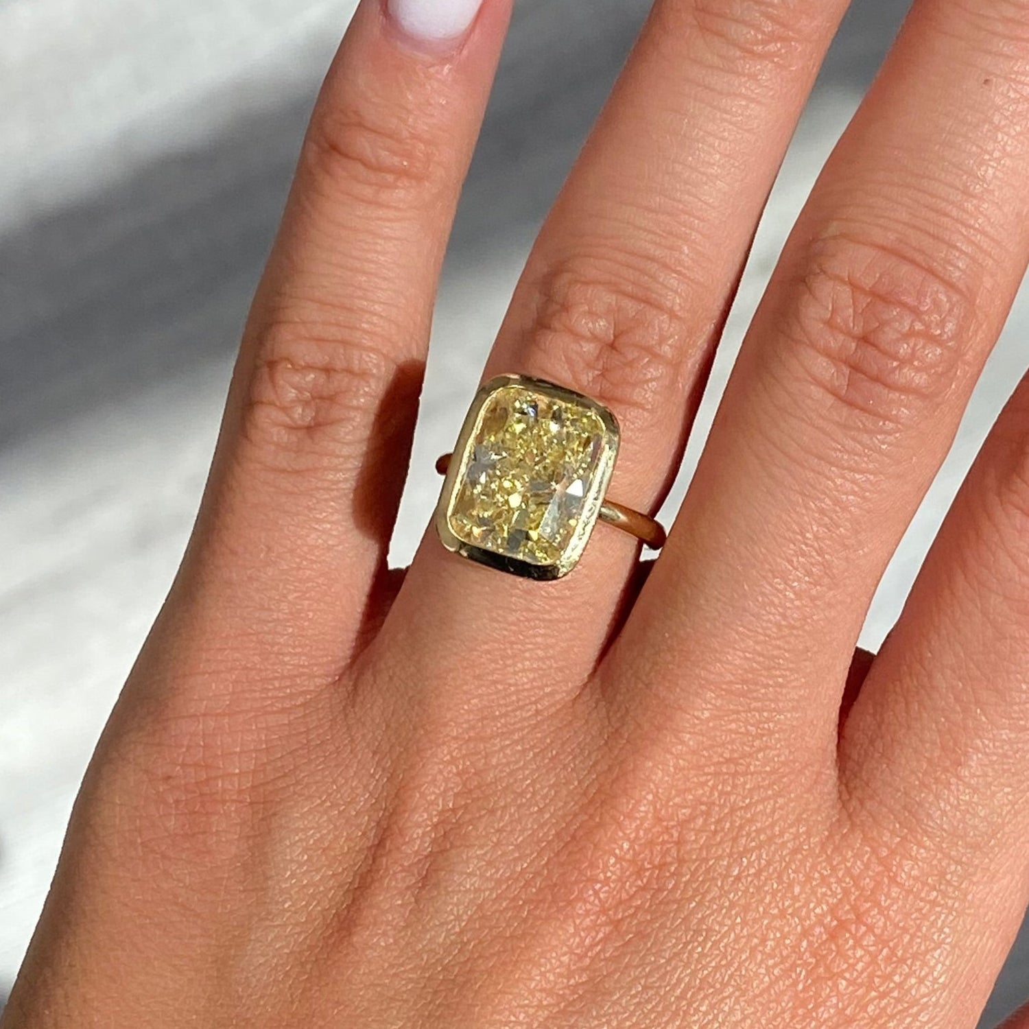 Bezel set ring featuring a GIA certified Fancy Yellow natural diamond with VS1 clarity.