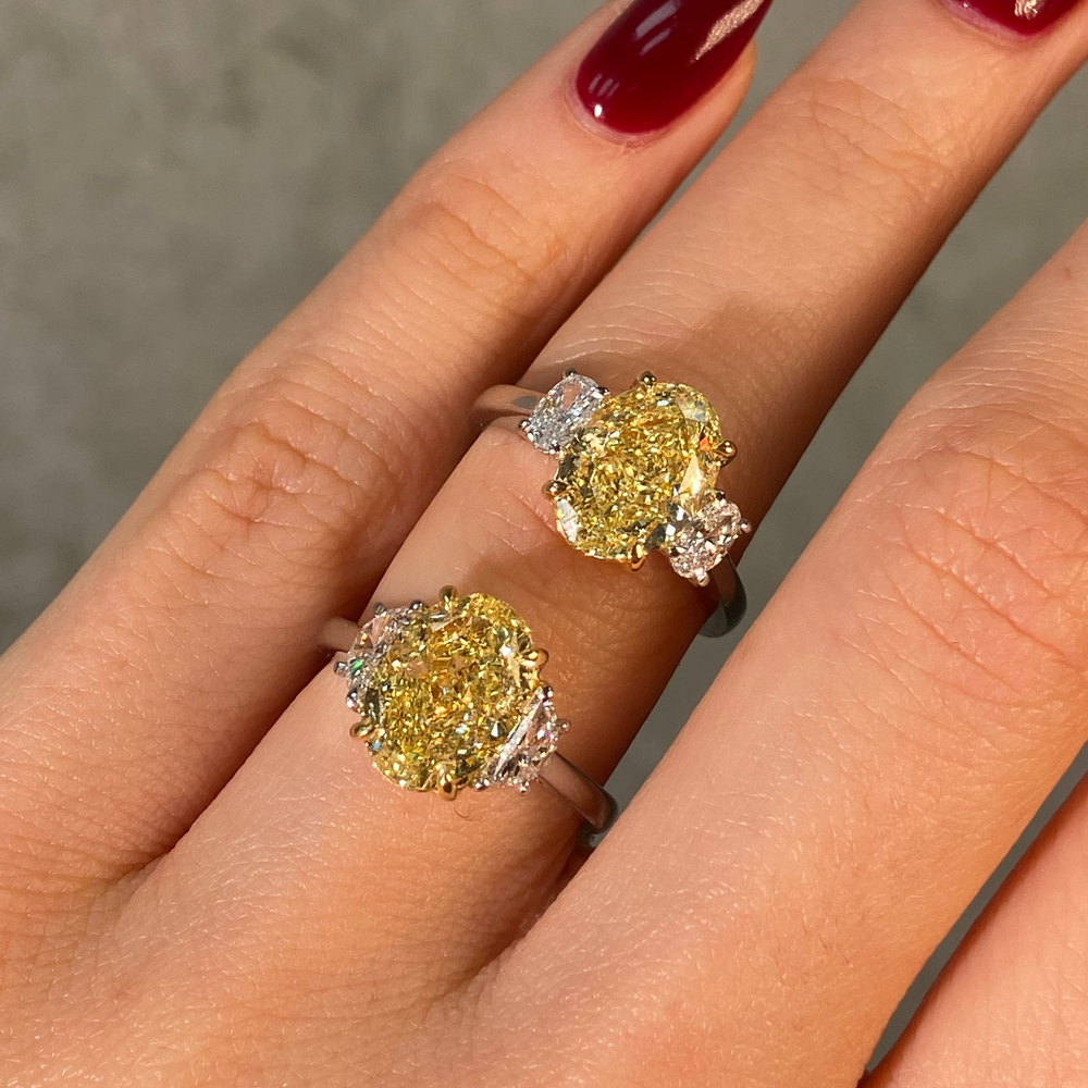 2 oval yellow diamond rings on female finger