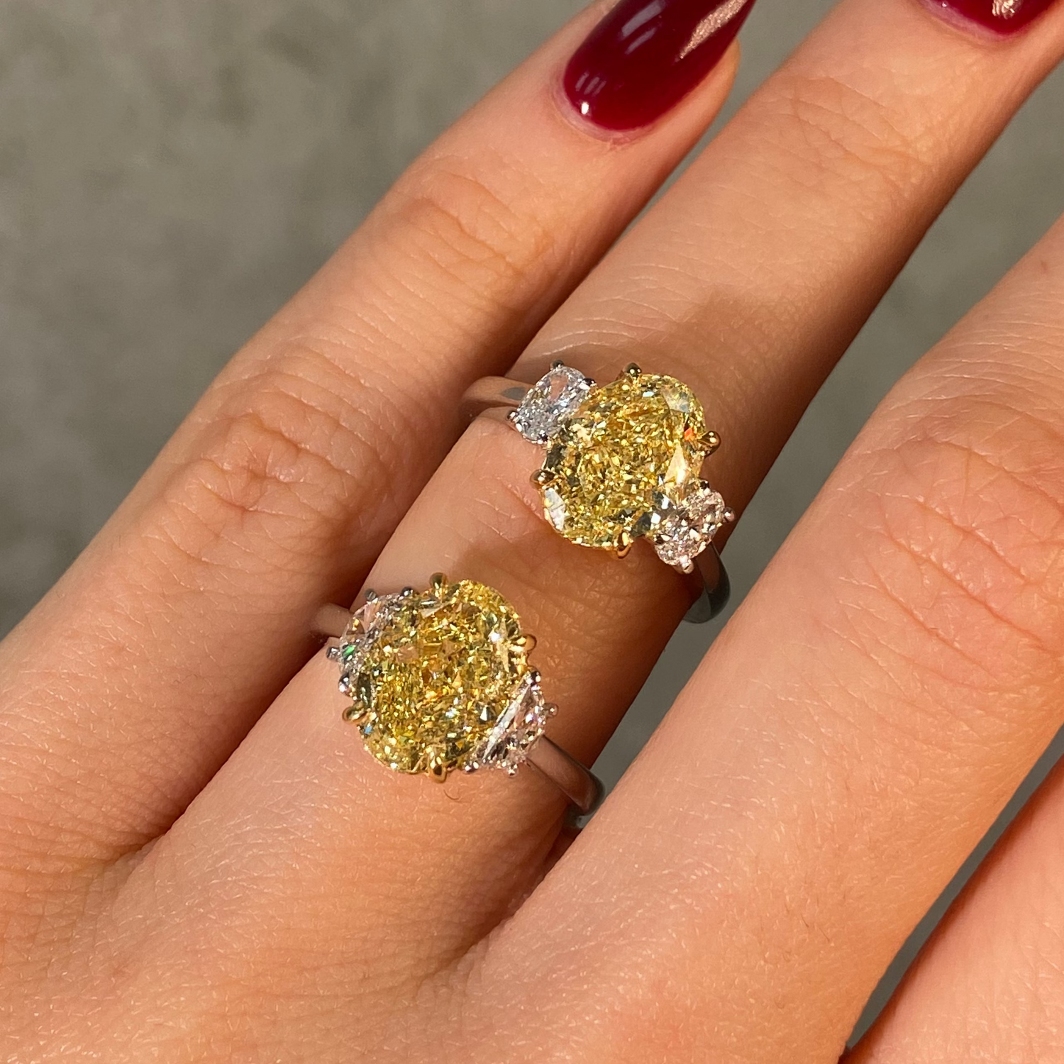 2 oval yellow diamond rings on female finger
