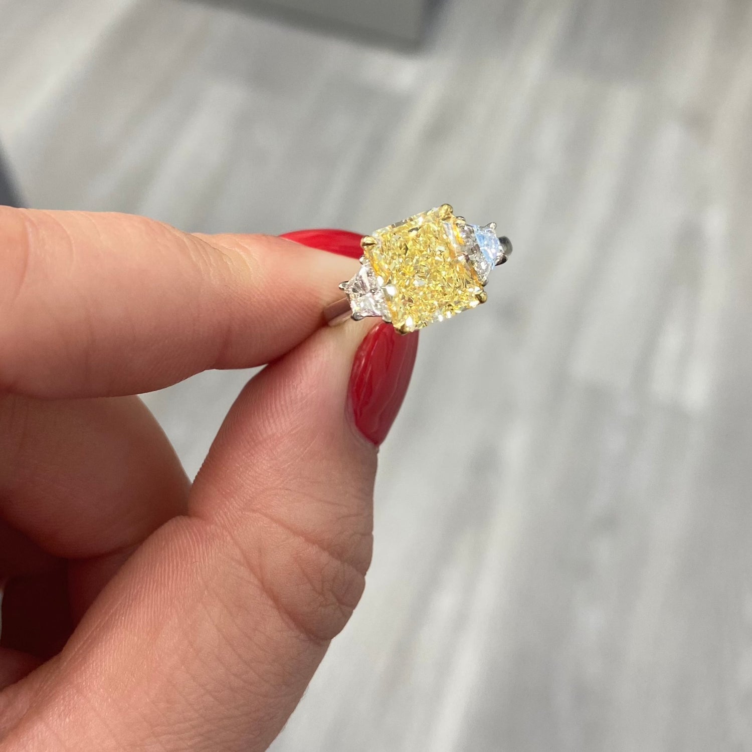 Fancy yellow elongated diamond three stone ring.