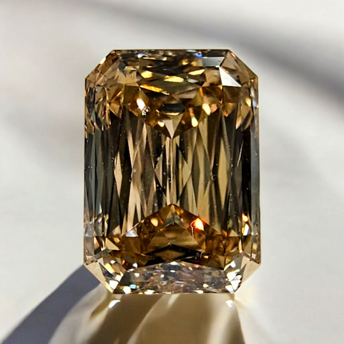 Elegant fancy brown emerald cut diamond with an elongated shape and a golden champagne tone.