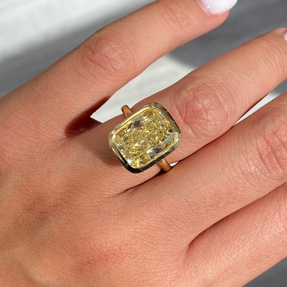 Bezel set ring featuring a GIA certified Fancy Yellow natural diamond with VS1 clarity.