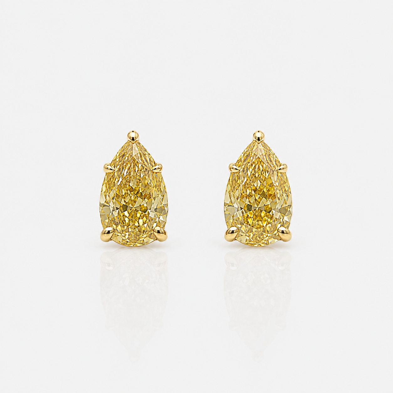 A pair of pear-cut yellow diamond stud earrings in yellow gold prong settings, GIA Certified 