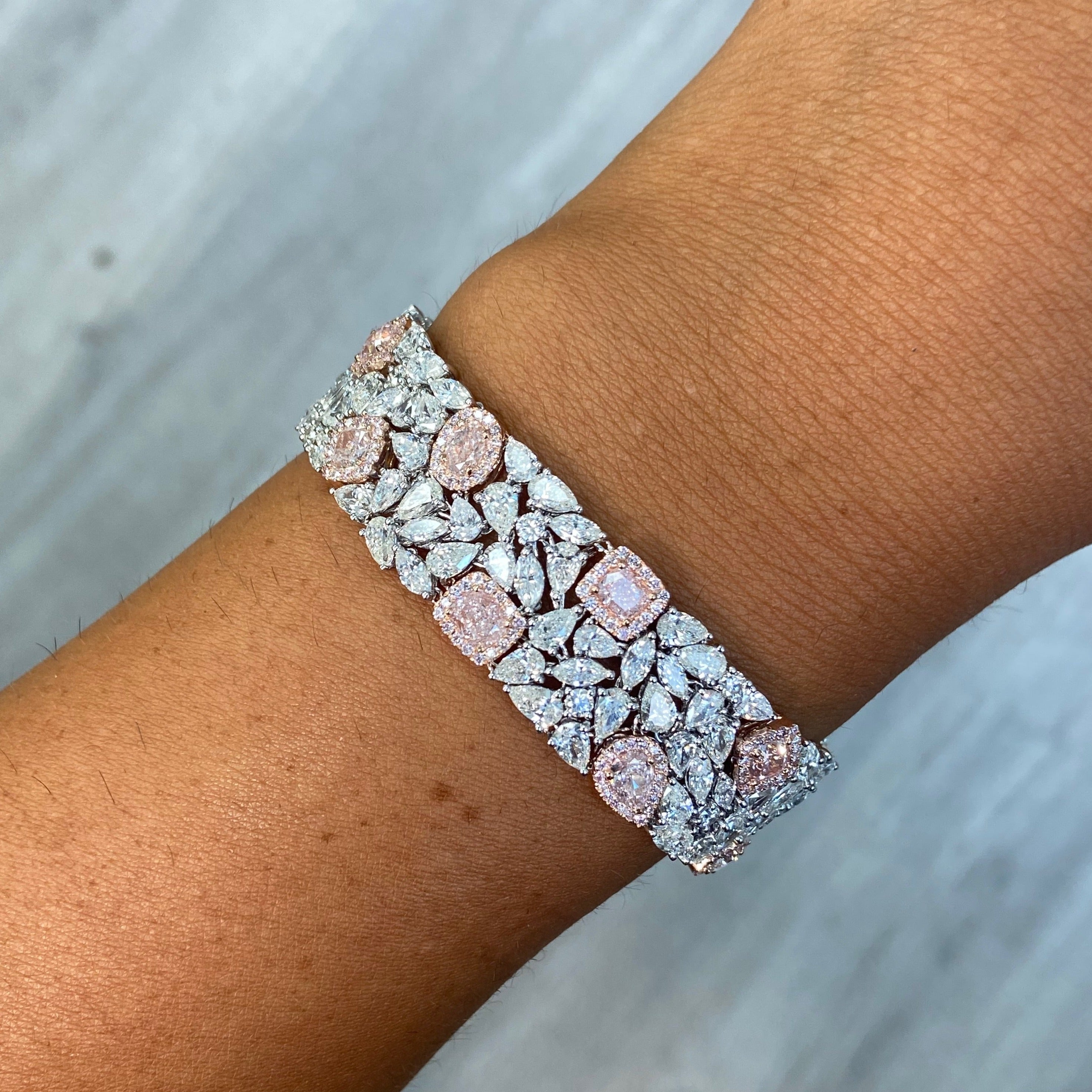 GIA certified light pink cushion and pear shape diamonds with white diamond bracelet.