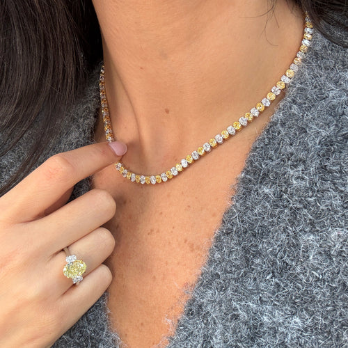 Necklace with yellow and white oval diamonds worn by female 