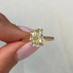 old mine yellow diamond antique cushion ring held by female 