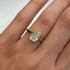 old mine yellow diamond antique cushion ring on female finger
