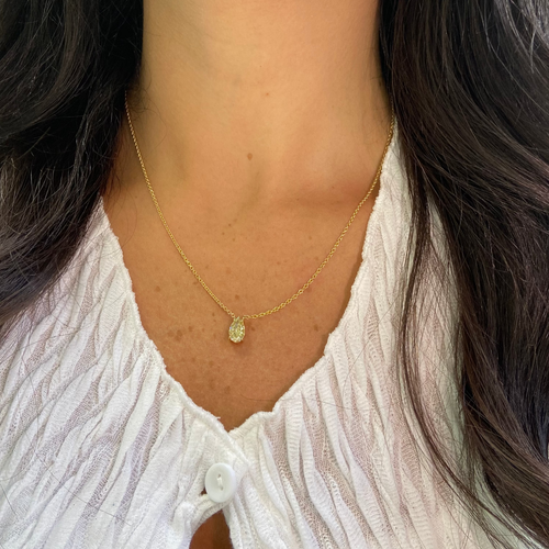 Gold necklace with a pear-shaped fancy yellow diamond pendant  worn by female 