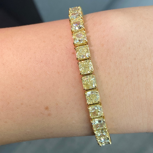 Elegant tennis bracelet featuring fancy yellow cushion-cut diamonds with exceptional clarity.