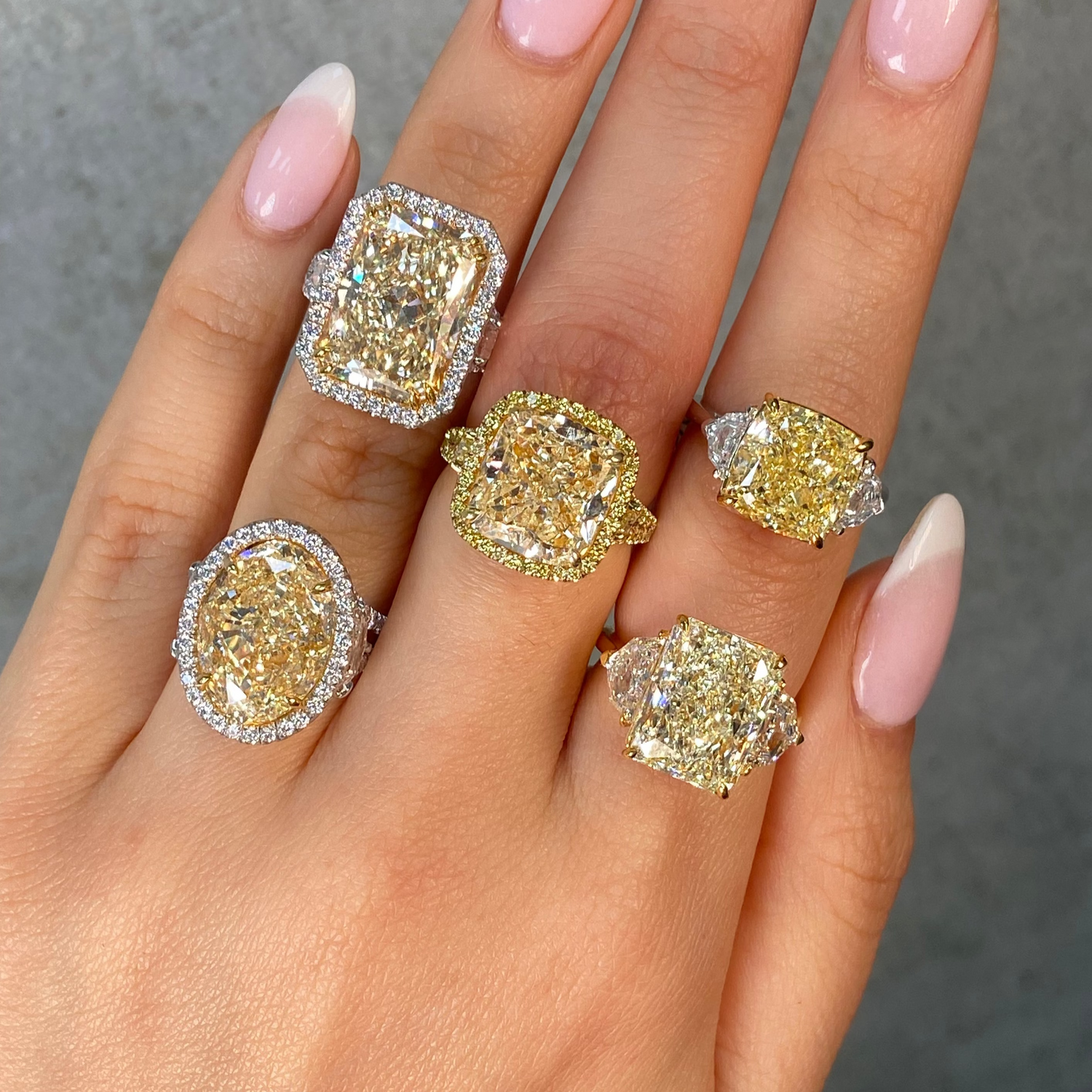 5 large yellow diamond rings on female hand 