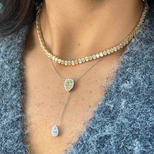 Necklace with yellow and white oval diamonds worn by female 