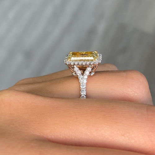 GIA certified light yellow elongated radiant diamond halo engagement ring with white diamonds.