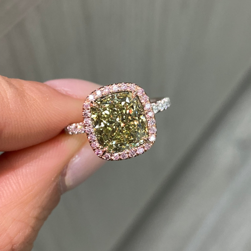 GIA certified greenish yellow cushion diamond in a pink halo engagement ring with VS1 clarity.