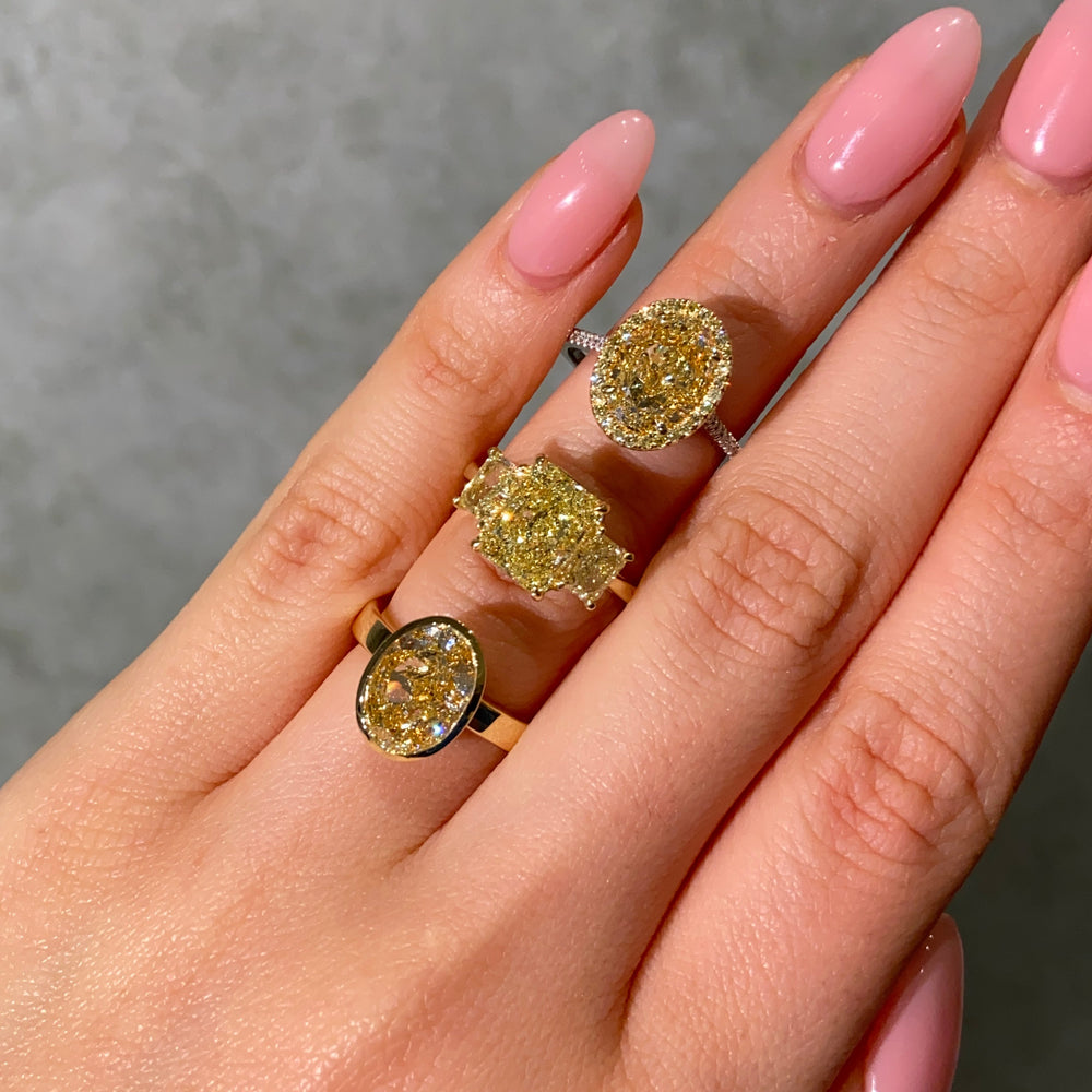 3 yellow Diamond Engagement Rings on female hand