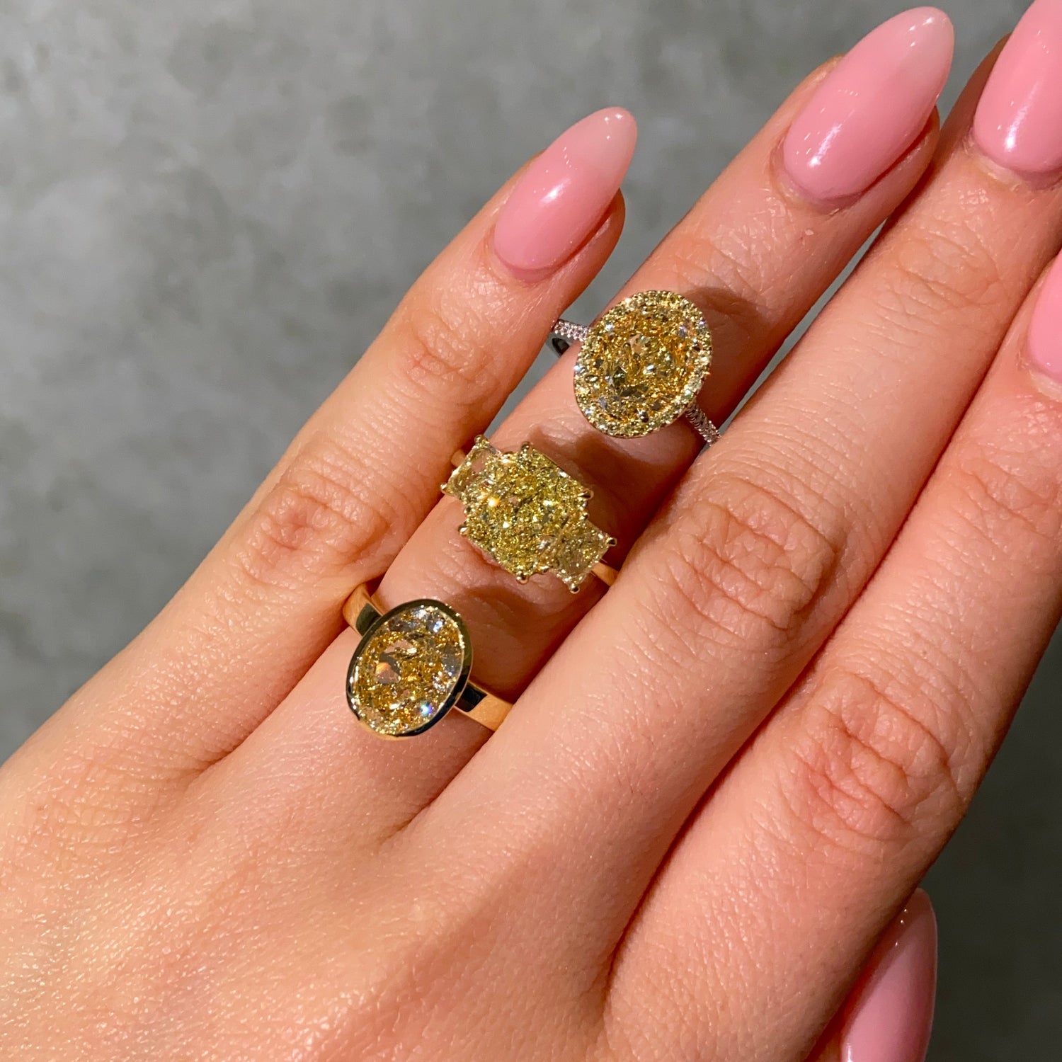 3 yellow Diamond Engagement Rings on female hand