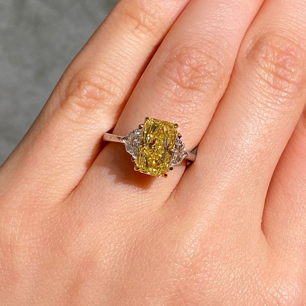 Fancy intense yellow elongated radiant cut ring female hand