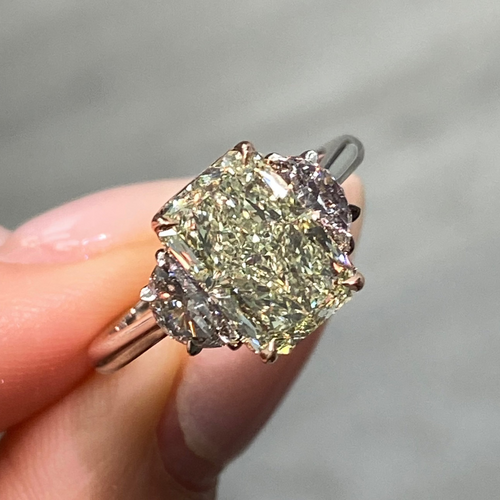GIA-certified greenish yellow diamond ring with a radiant cut center stone and VVS2 clarity.