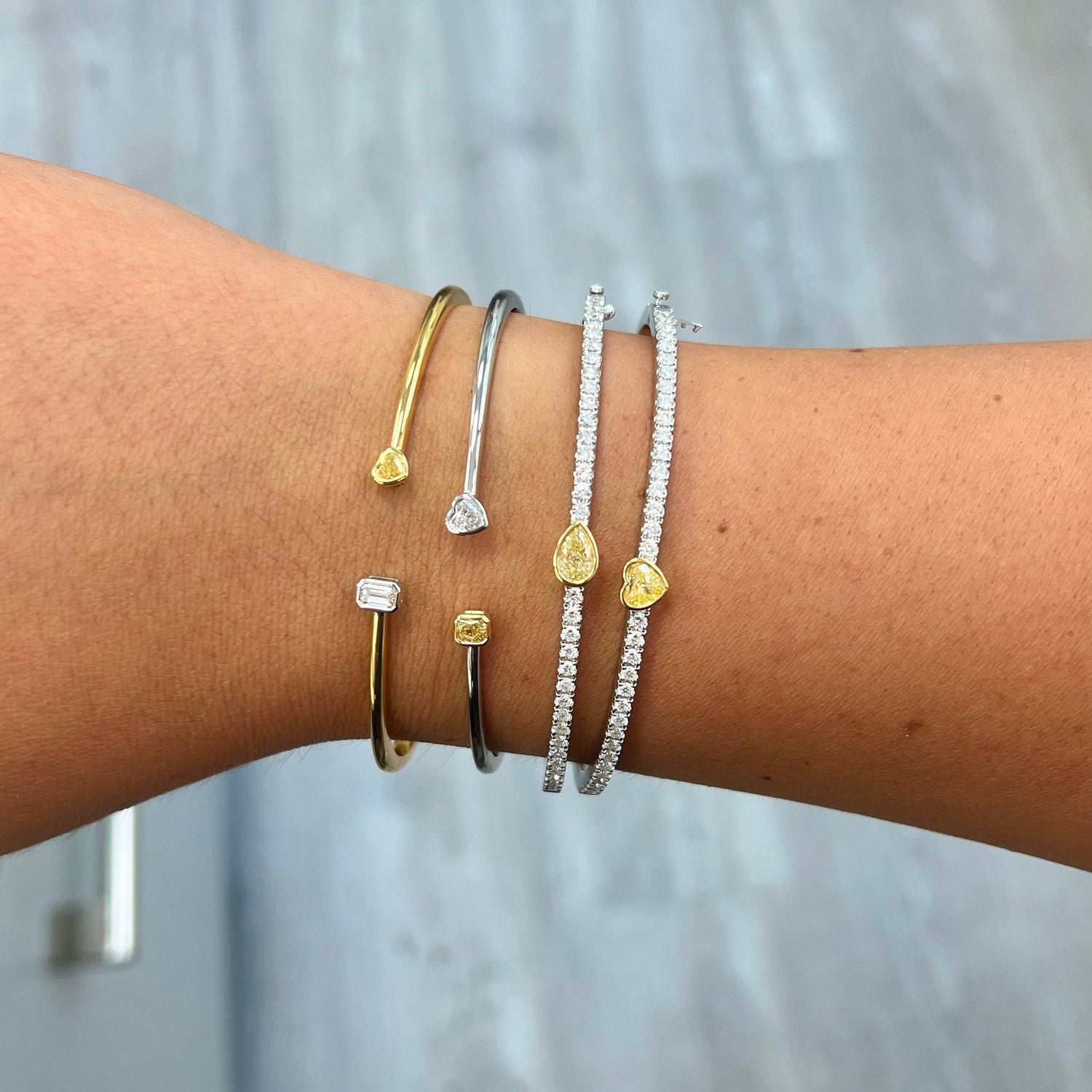 Unique heart shaped yellow diamond bangle with elongated white round diamonds and SI-VS1 clarity.