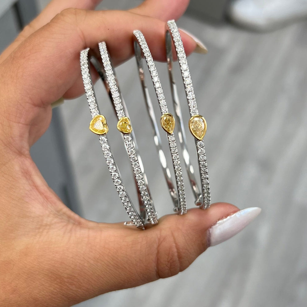 Unique heart shaped yellow diamond bangle with elongated white round diamonds and SI-VS1 clarity.