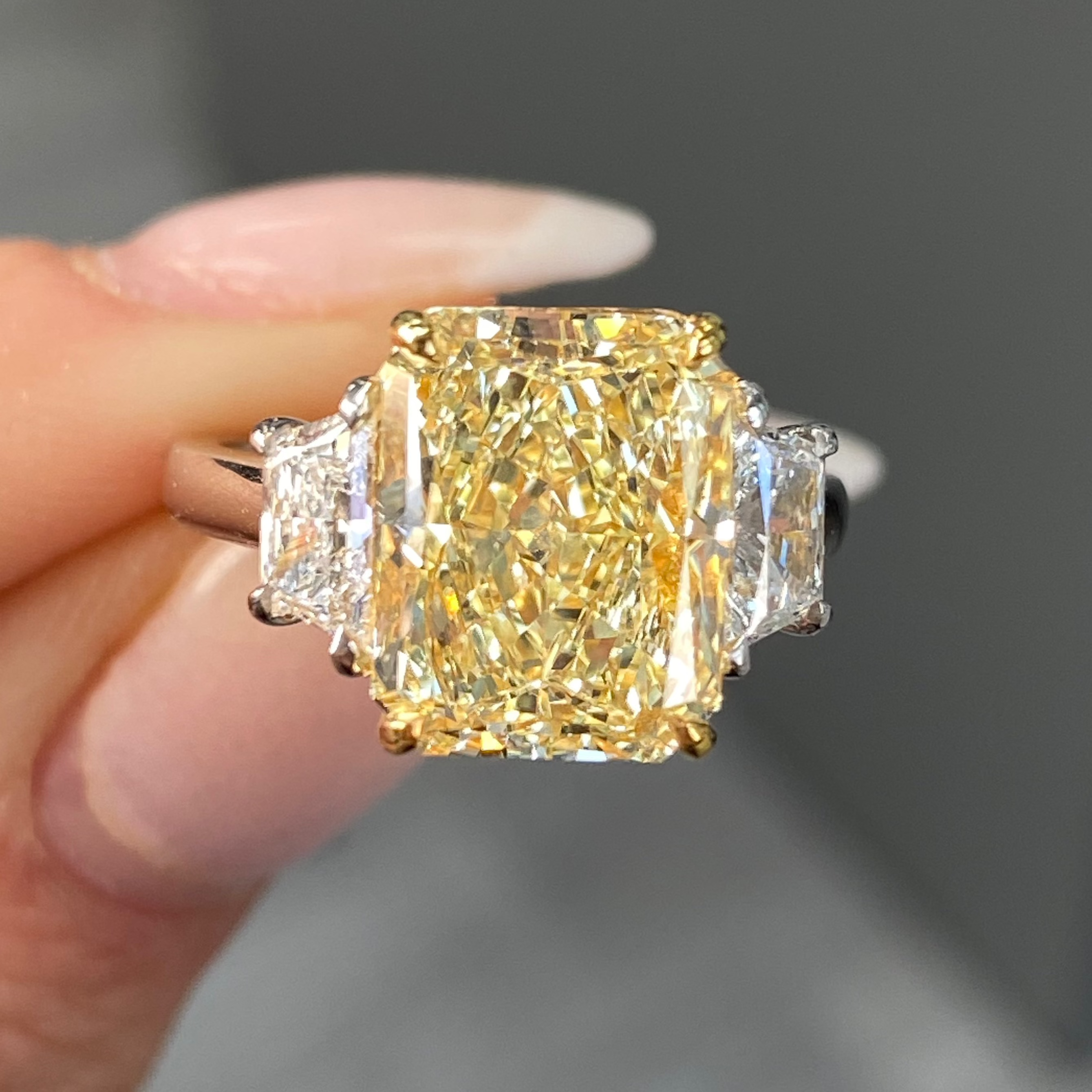 Elegant fancy light yellow elongated radiant diamond ring with VS2 clarity, unique and striking design.