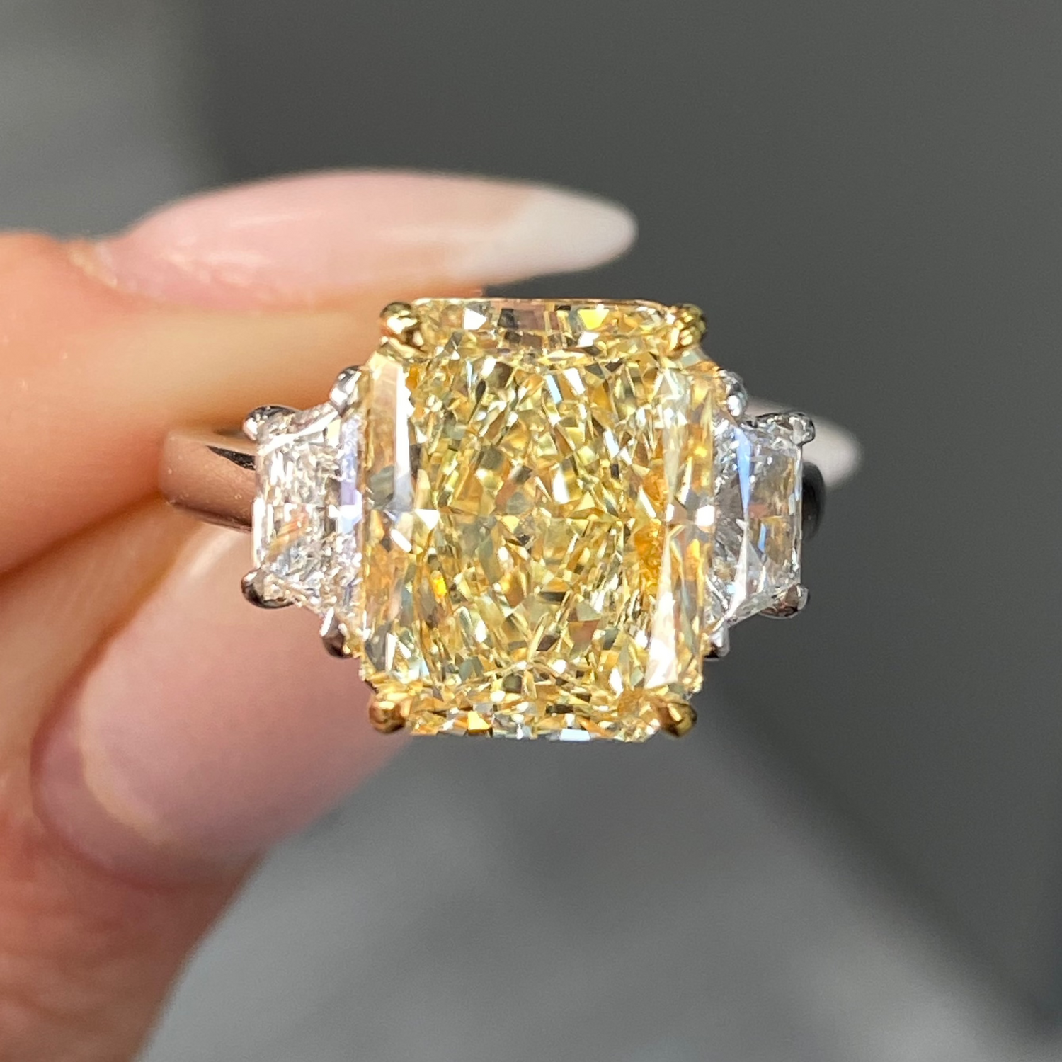 Elegant fancy light yellow elongated radiant diamond ring with VS2 clarity, unique and striking design.