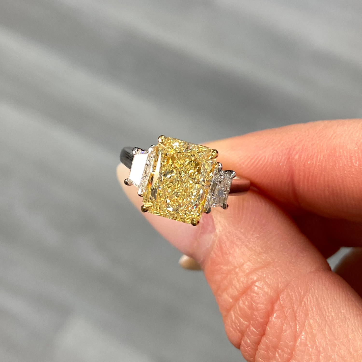 Fancy light yellow elongated radiant cut diamond engagement ring with VVS1 clarity.