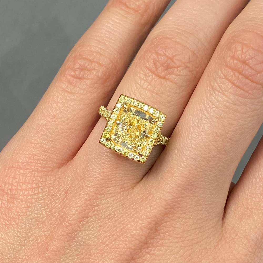 GIA certified light yellow elongated cushion cut halo diamond engagement ring with canary yellow, SI1 clarity.