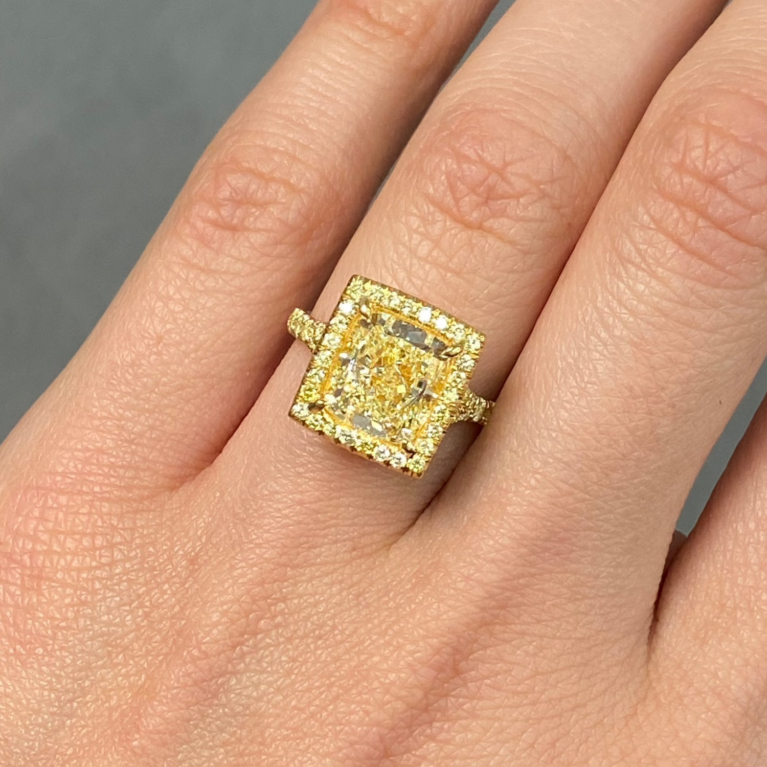 GIA certified light yellow elongated cushion cut halo diamond engagement ring with canary yellow, SI1 clarity.