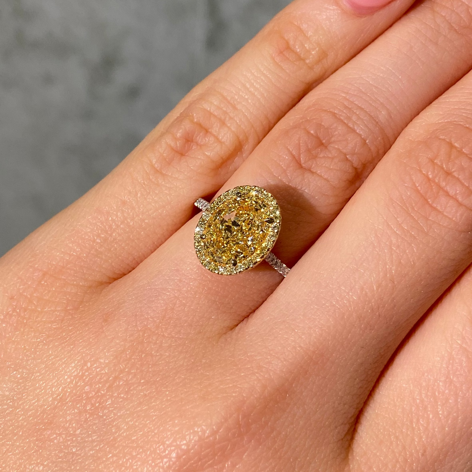 Two Tone Oval Diamond Halo Engagement Ring on female hand