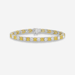 a two-tone, alternating yellow and white color diamond tennis bracelet on a white background