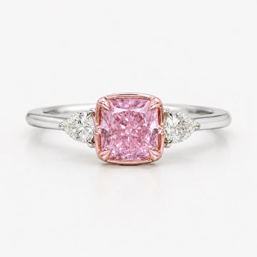 Ring with a natural pink diamond and two smaller diamonds on a white background