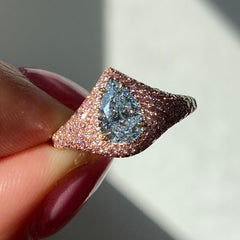 Unique GIA certified light blue pear shape diamond ring set with natural pink diamonds.