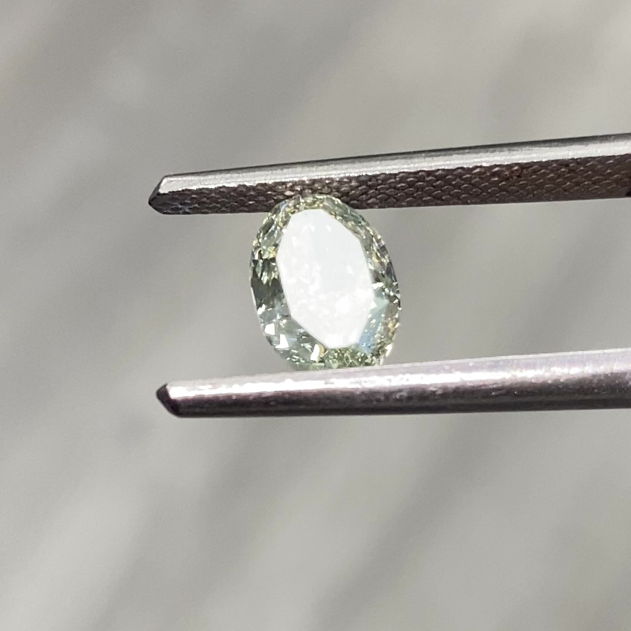 Video of Oval-shaped green diamond on a light gray background
