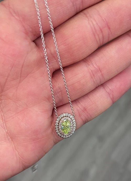 Fancy yellow-green oval diamond pendant with a double halo design and SI1 clarity.