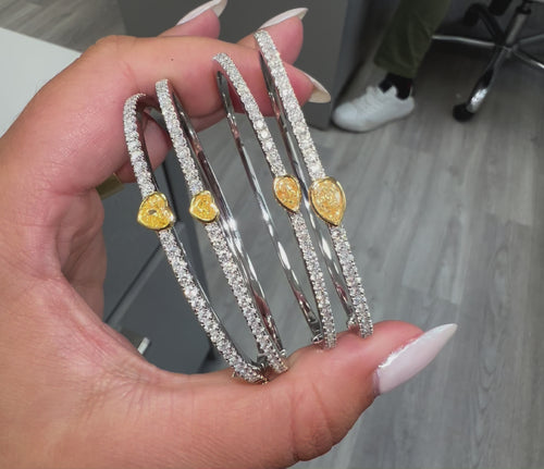 Fine heart shaped yellow diamond bangle with white round diamonds.