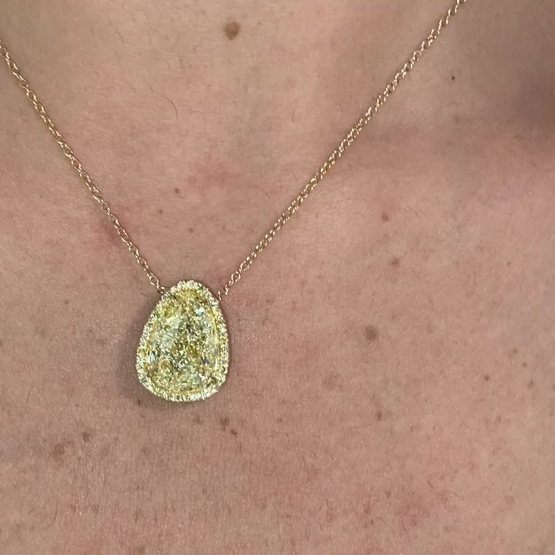 Old money light yellow pear-shaped diamond pendant, accented by a radiant halo of yellow diamonds with SI1 clarity.
