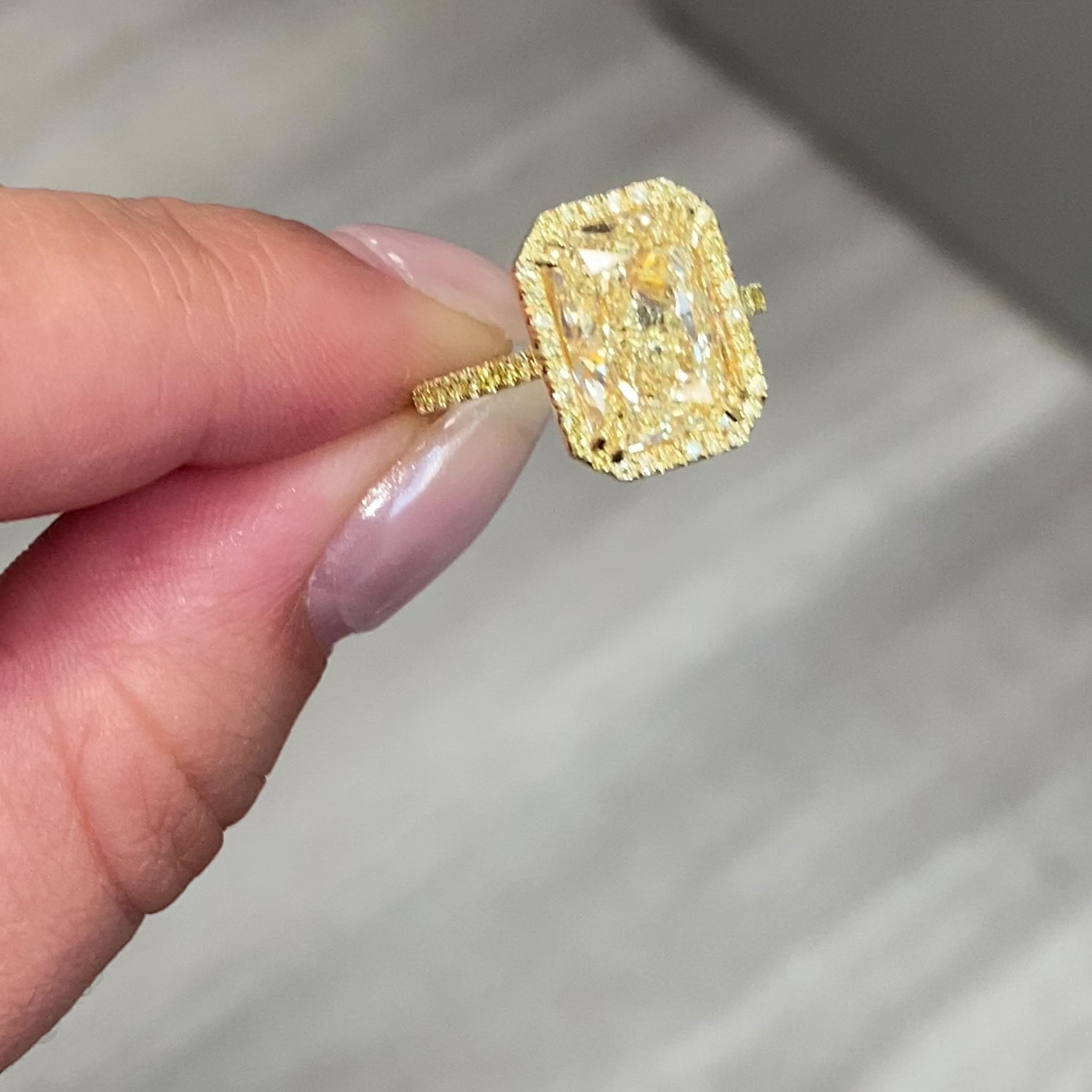 Old money yellow halo diamond engagement ring featuring a GIA certified light yellow elongated radiant diamond with VS2 clarity.