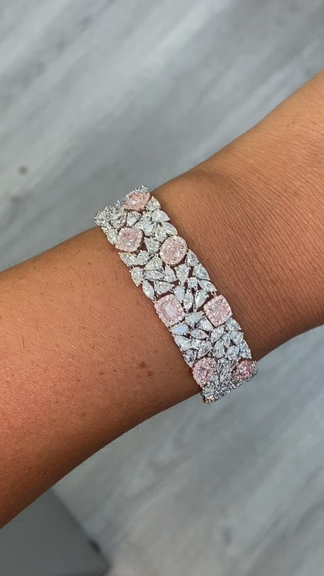 GIA certified light pink cushion and pear shape diamonds with white diamond bracelet.