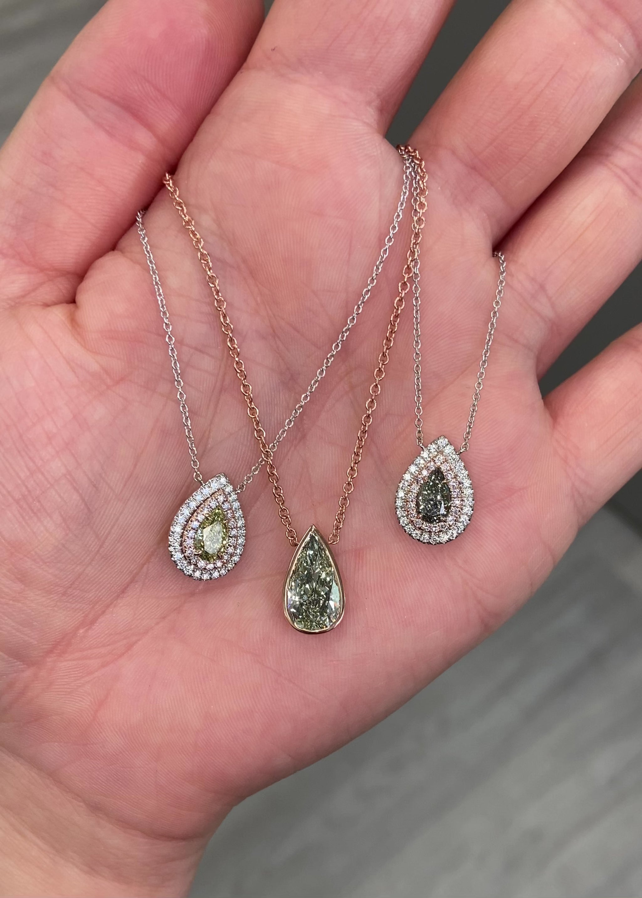 Stunning green pear-shaped diamond pendant in a pink bezel setting with SI1 clarity.