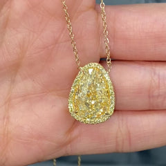Old money light yellow pear-shaped diamond pendant, accented by a radiant halo of yellow diamonds with SI1 clarity.