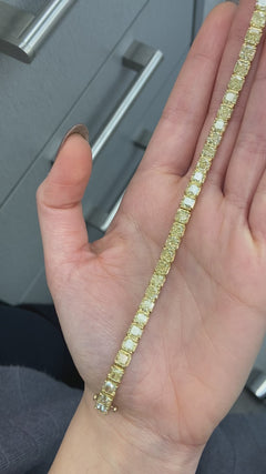Elegant tennis bracelet featuring fancy yellow cushion-cut diamonds with exceptional clarity.