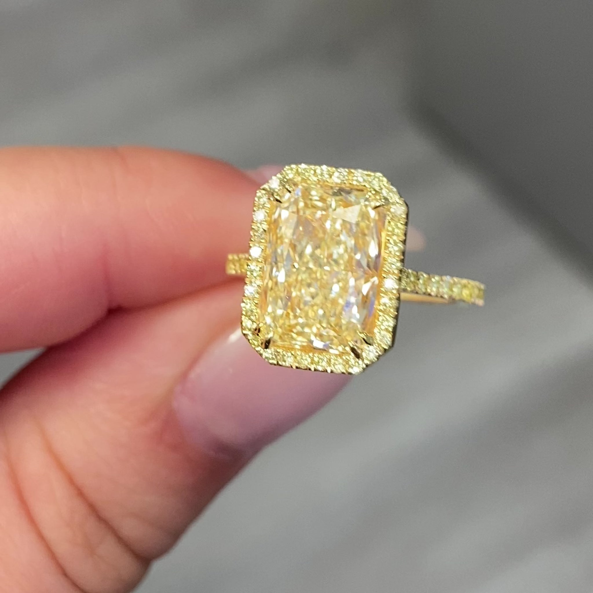 Old money yellow halo diamond engagement ring featuring a GIA certified light yellow elongated radiant diamond with VS2 clarity.