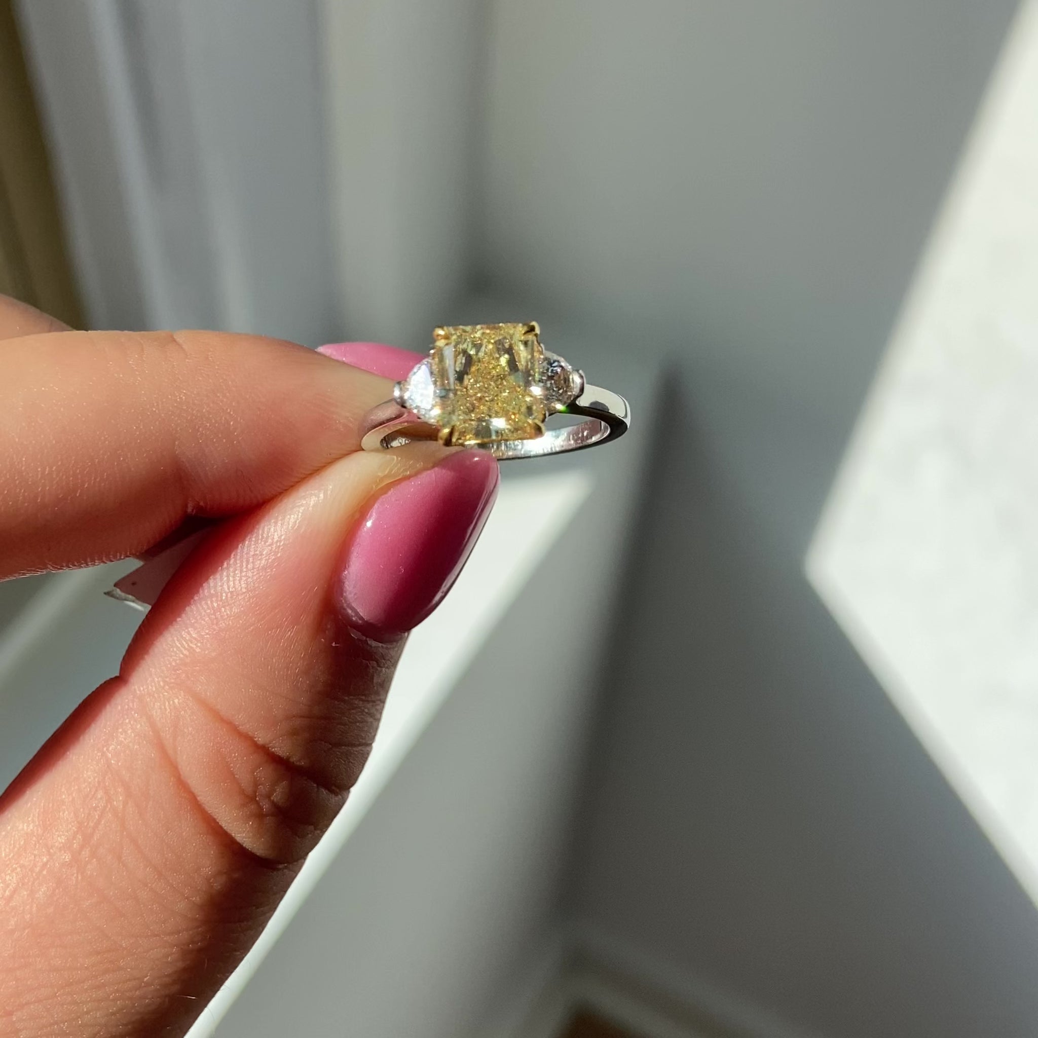 Elegant Fancy Yellow radiant cut diamond engagement ring with VS2 clarity and GIA certification.