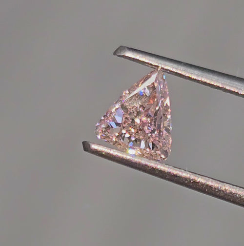 GIA certified Fancy Orangy Pink trillion diamond with SI1 clarity and vibrant hue. 