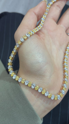Video of Necklace with yellow and white oval diamonds held by female 