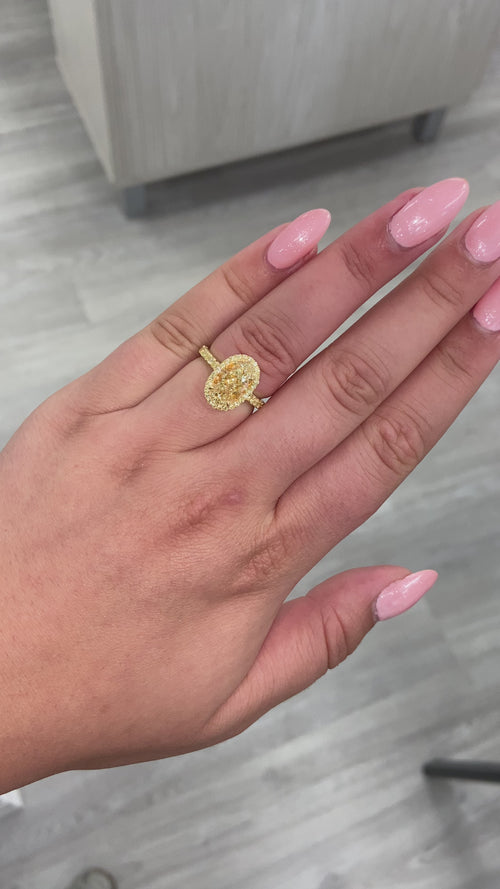 Light Yellow Oval diamond ring set in 18 karat yellow gold with yellow round diamonds.